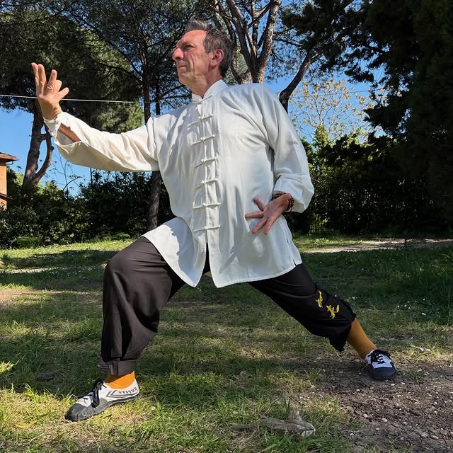 Il maestro pratica all'aperto con un'arma tradizionale